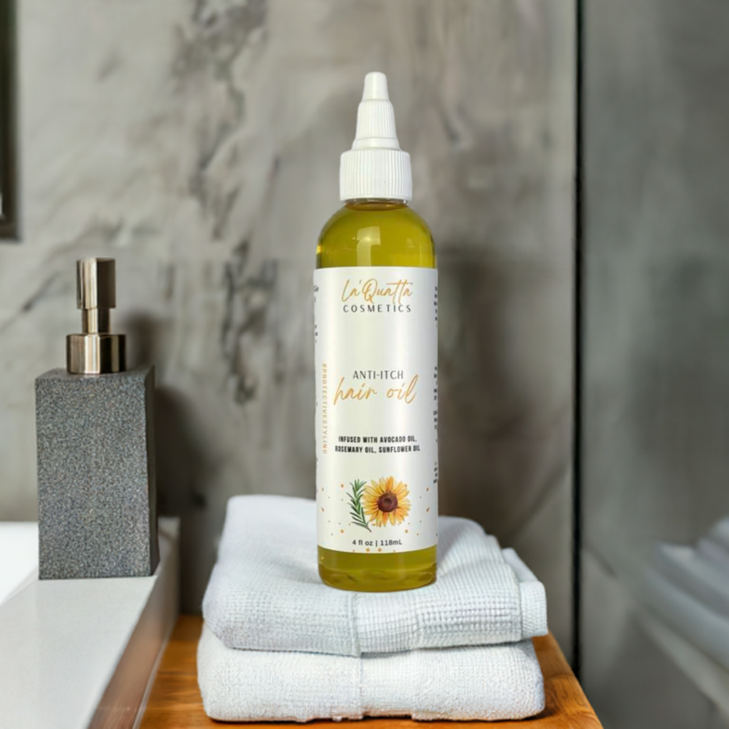 A bottle of Anti-Itch Hair Oil placed on a stack of white towels, with a bathroom setting in the background. The bottle has a white label with yellow text and a sunflower illustration.